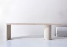 a white table sitting in front of a white brick wall