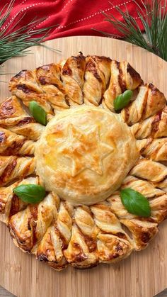 a pastry on a wooden platter with green garnishes and pine needles