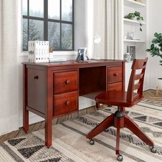 a wooden desk with two drawers and a chair in front of a large window on a rug