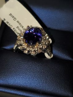 a ring with a purple stone surrounded by diamonds