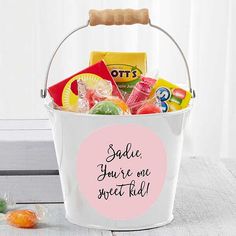 a white bucket filled with candy and candies