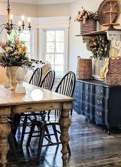 a dining room table with chairs and baskets on the wall above it, along with other furniture