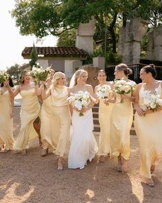 the bridesmaids are all dressed in yellow dresses and holding bouquets with white flowers