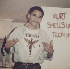 a young man standing in front of a sign