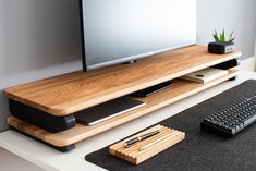 a flat screen tv sitting on top of a wooden shelf next to a keyboard and mouse