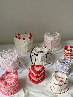 a table topped with lots of cakes covered in frosting