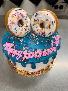 there is a birthday cake with two donuts on it