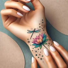 a woman's hand with a flower and dragon tattoo on her left side arm