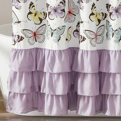 a shower curtain with butterflies on it and purple ruffles around the bottom tier