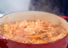 a red pot filled with food on top of a stove