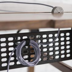 a close up of a metal object with wires attached to the back of it, on top of a wooden table