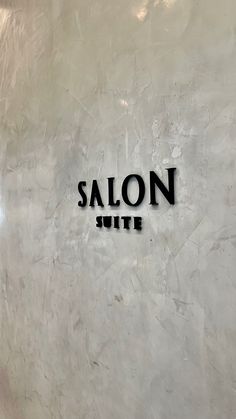 the salon wite sign is on the wall