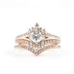 a white diamond ring with two rows of diamonds on the band and an intricate design