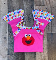 Elmo Summer 1 Piece Romper Outfit This cute boutique Elmo romper outfit would be perfect for a Sesame Street Elmo theme birthday party, or just a fun day out in the sun. Outfit is hot pink knit trimmed in a rainbow houndstooth print with an Elmo applique on front. Elmo Sesame Street Theme 100% Stretch Knit/Cotton Wash Warm tumble dry low iron if needed HANDMADE IN USA Sun Outfit, Bug Clothing, Elmo Sesame Street, Sesame Street Elmo, Street Girl, Theme Birthday Party, Pink Knit, Cute Boutiques, Romper Outfit