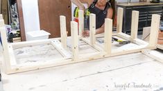 a woman is working on some wooden structures