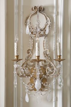 a chandelier hanging from the side of a wall