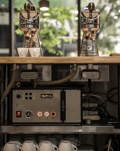 two coffee cups sitting on top of a machine