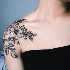 a woman's shoulder with flowers and leaves on it