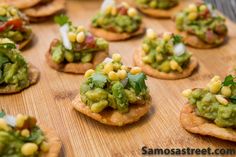 small crackers topped with guacamole, corn and cilantro sauce