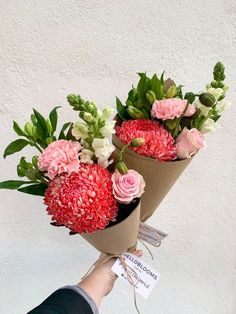 a person holding two bouquets of flowers in their hands