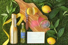 lemons and other ingredients are laid out on the grass next to a cutting board