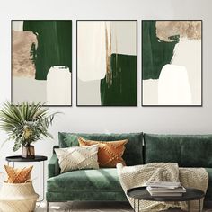 a living room with green couches and paintings on the wall above them in neutral colors