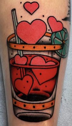 a tattoo on the leg of a man with hearts in a cup and candy canes