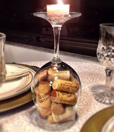 a wine glass filled with corks sitting on top of a table next to plates