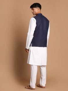 VASTRAMAY Men's Navy Blue Solid Nehru Jacket With White Solid Kurta And White Cotton Pant Style Pyjama Set Elevate your traditional wardrobe with this stylish ensemble from VASTRAMAY. The navy blue Nehru jacket pairs perfectly with the classic white kurta and pyjama, offering a sophisticated yet comfortable look for any occasion. Whether it's a wedding, festive celebration, or a formal event, this set ensures you stand out with elegance and grace. Features Elegant navy blue Nehru jacket Classic White Cotton Nehru Jacket, Traditional Fitted Nehru Jacket With Pockets, Blue Nehru Jacket For Festive Workwear, Festive Blue Nehru Jacket For Workwear, Festive Blue Nehru Jacket For Work, Fitted Nehru Jacket For Eid, Fitted Nehru Jacket For Workwear And Eid, Traditional Nehru Jacket With Stand Collar For Work, Nehru Jacket For Eid Workwear