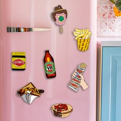 a pink refrigerator with stickers on it