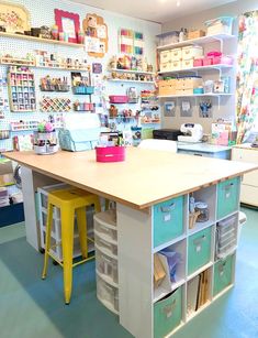 an organized craft room with storage bins and colorful stools in front of the desk