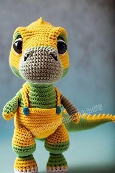 a crocheted stuffed animal is wearing a yellow and green outfit