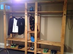 a wooden shelf with shoes and other items on it in a room next to a bike