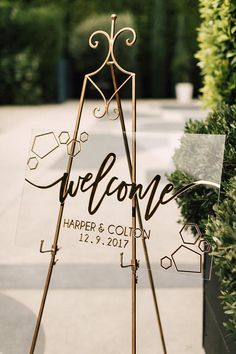 a welcome sign is standing in front of some bushes