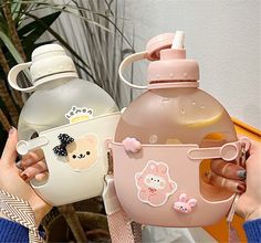 two women holding up bottles with stickers on them, one is pink and the other is white