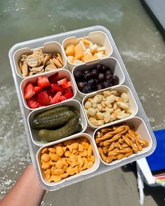 a person holding a tray with different types of food in it