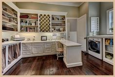 a laundry room with wood floors and white cabinets is pictured in this image, the washer sits next to the dryer