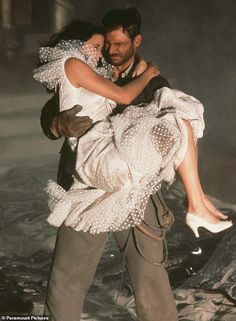 an autographed photo of a man and woman hugging each other in the rain