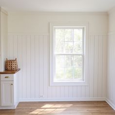 an empty room with white painted walls and wood flooring is seen in this image