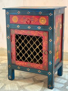 an ornate painted cabinet with lattice design on the front and sides, sitting on a tiled floor