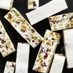 several pieces of white chocolate with nuts and dried cherries on top, scattered around