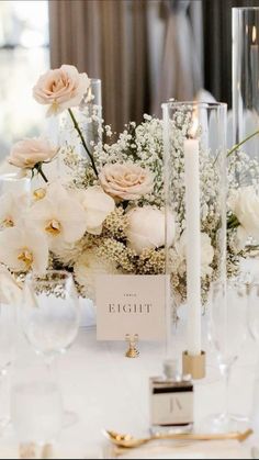 there is a table with flowers and candles on it, along with other place settings