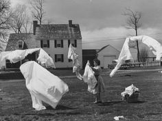 an old black and white photo of some people in the grass with clothes on them