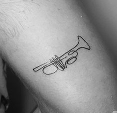 a black and white photo of a man's arm with a musical instrument tattoo on it