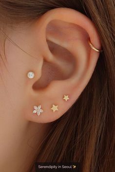 an ear with three small stars on the top and one smaller star on the bottom