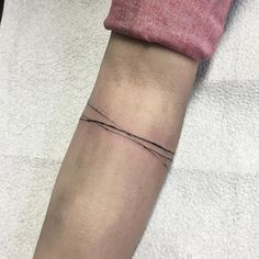 a person's arm with a small tattoo on the left side of their arm