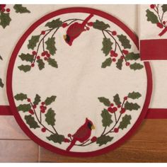 two placemats with holly and cardinals on them