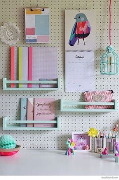 a white desk topped with lots of shelves filled with books and paper clips next to a birdcage