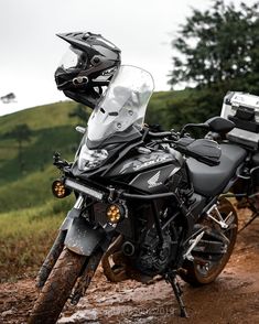 a black motorcycle parked on top of a muddy road