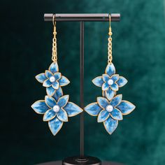 These hand-painted flowers, inspired by the iconic Mardi Gras float flowers, will bring a little bit of New Orleans style to your ears! Based on the Henri Clematis flower, this pair sparkles in rich blues and gold and white pearl centers add an extra dash of elegance.  Dimensions: 3.875in x 1.75in Each flower is carefully shaped out of paper and painted before being coated in a durable clear acrylic, creating pieces that are bright and bold while being incredibly lightweight and wearable. Proudl Handmade Enamel Drop Flower Earrings, Handmade Enamel Flower Shaped Earrings, Elegant Hand Painted Drop Flower Earrings, Blue Flower-shaped Hand Painted Earrings, Blue Hand Painted Flower Earrings, Artistic Hand Painted Flower Earrings, Mardi Gras Float, New Orleans Style, Clematis Flower